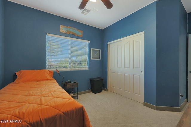 carpeted bedroom featuring a closet and ceiling fan