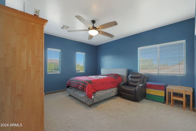 bedroom with multiple windows, light colored carpet, and ceiling fan