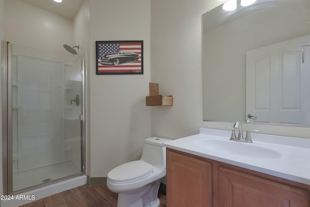 bathroom with a shower with door, vanity, hardwood / wood-style floors, and toilet