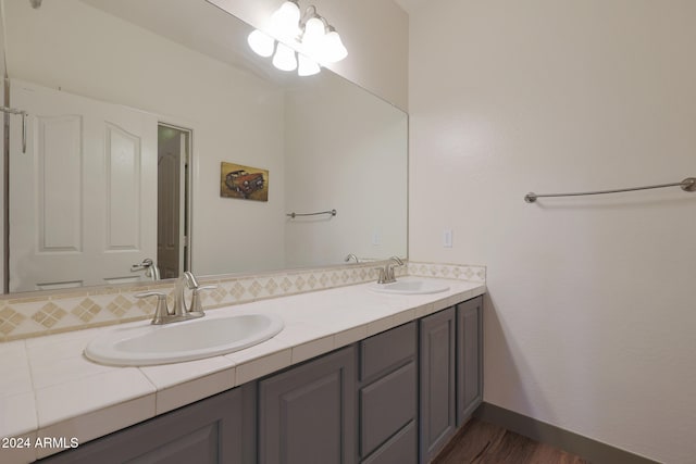 bathroom featuring vanity, hardwood / wood-style floors, and backsplash