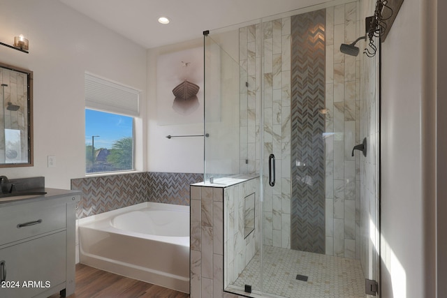 bathroom with vanity, hardwood / wood-style floors, and separate shower and tub