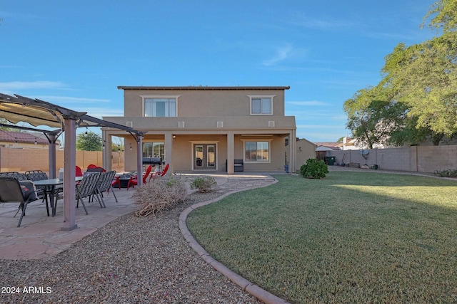 rear view of house with a patio, a pergola, and a lawn