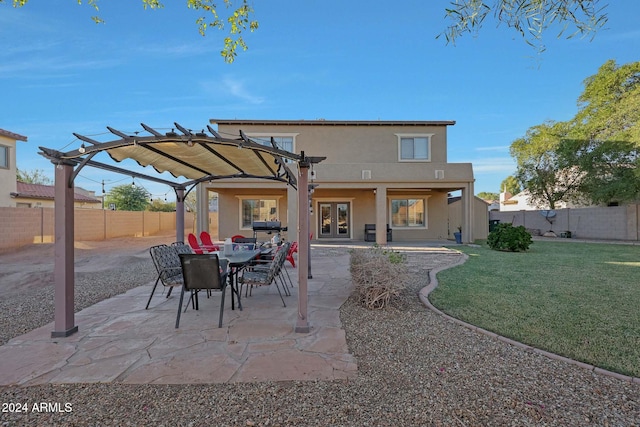 rear view of house with a pergola, a patio, and a lawn