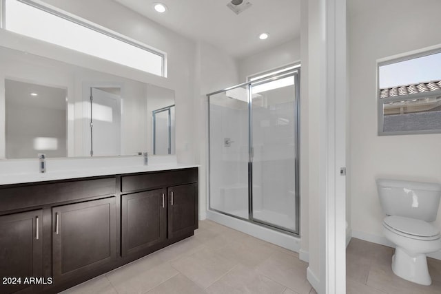 bathroom featuring a shower with door, toilet, and a wealth of natural light