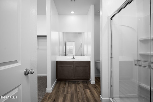 24593 W St Catherine Ave, Buckeye, AZ 85326 - bathroom with baseboards, a shower stall, wood finished floors, and vanity