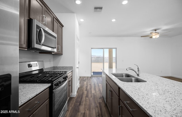 24593 W St Catherine Ave, Buckeye, AZ 85326 - kitchen with a sink, dark wood-style flooring, appliances with stainless steel finishes, and dark brown cabinetry