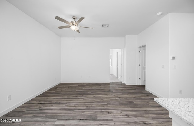 24593 W St Catherine Ave, Buckeye, AZ 85326 - empty room featuring visible vents, a ceiling fan, baseboards, and dark wood-type flooring