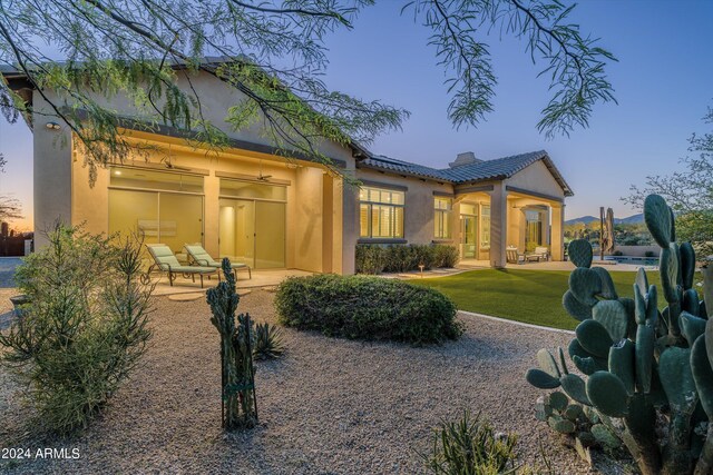 yard at dusk featuring a fenced in pool and a patio area