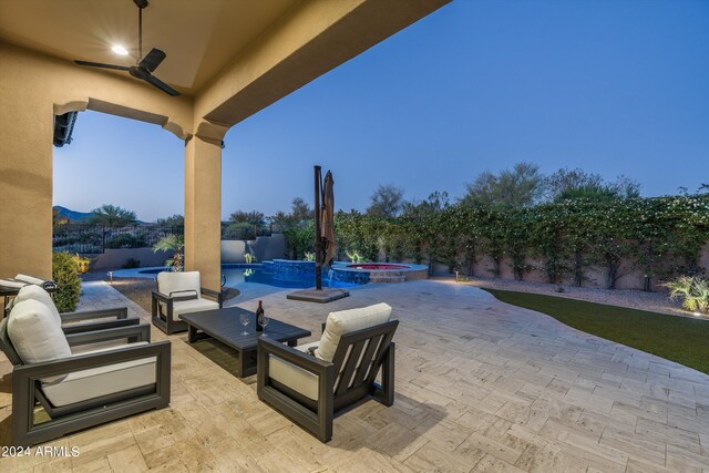 patio terrace at dusk with an outdoor living space, an in ground hot tub, and ceiling fan