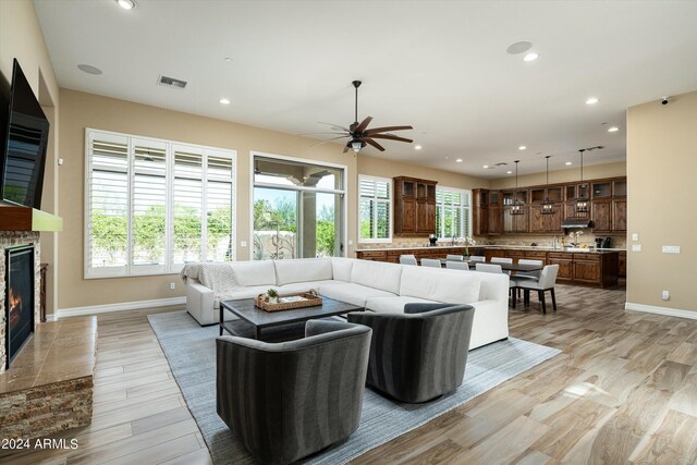 living room with light wood-type flooring, plenty of natural light, and ceiling fan