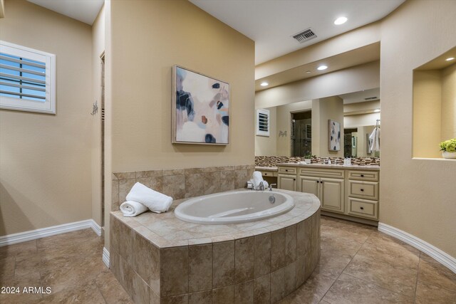 bathroom with tiled bath and vanity