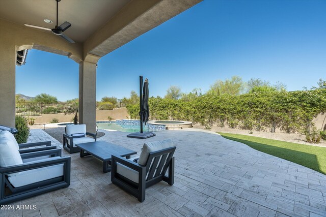 view of patio featuring ceiling fan and a swimming pool with hot tub