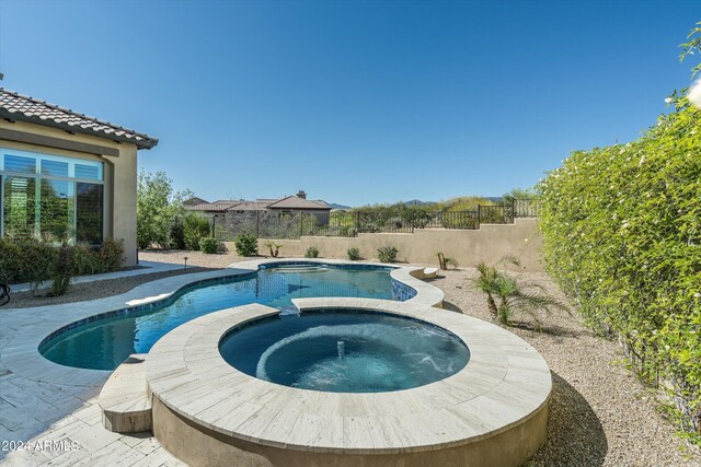 view of pool with an in ground hot tub