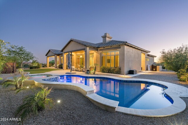 pool at dusk with a patio