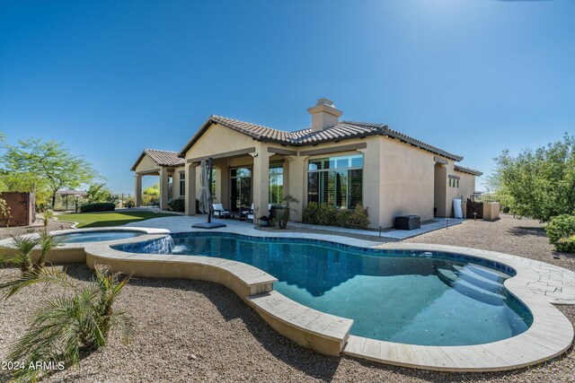 view of pool featuring a patio area and an in ground hot tub