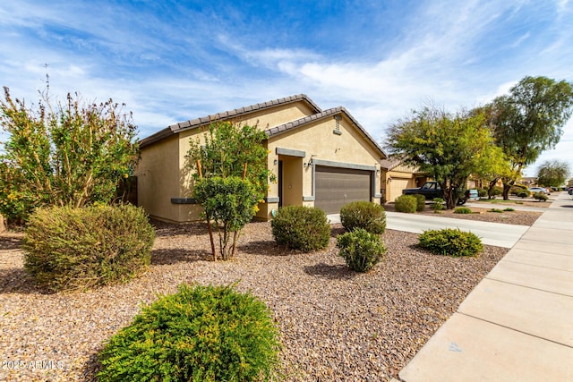 view of front of house featuring a garage, driveway, and stucco siding