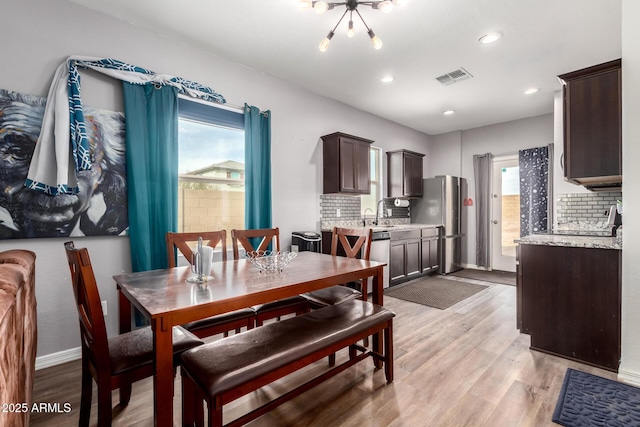 dining area featuring baseboards, visible vents, plenty of natural light, and light wood finished floors