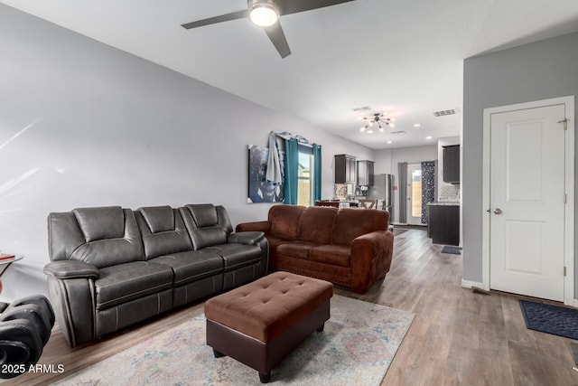 living area featuring a ceiling fan, visible vents, and wood finished floors