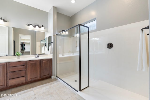 bathroom featuring tile patterned flooring, a shower stall, and vanity