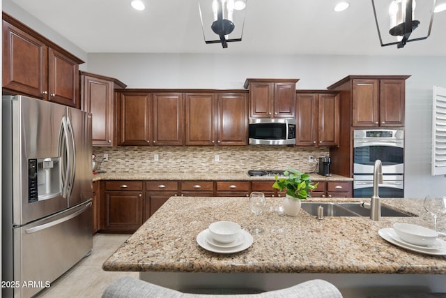 kitchen with light stone counters, a breakfast bar area, stainless steel appliances, and decorative backsplash