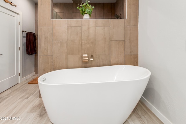 bathroom with a bath and hardwood / wood-style flooring