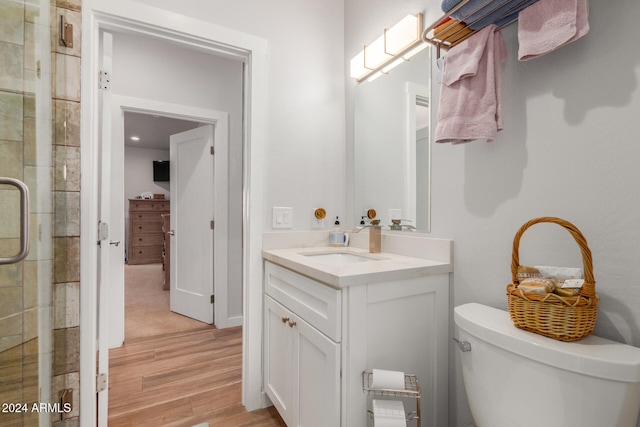 bathroom featuring hardwood / wood-style floors, vanity, toilet, and an enclosed shower