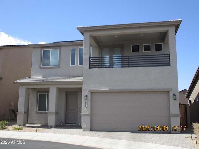 8026 S 6th Dr, Phoenix, AZ 85041 - view of front of home with driveway, an attached garage, a balcony, and stucco siding