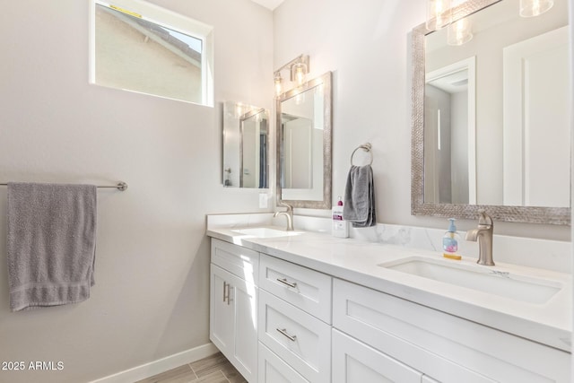 8026 S 6th Dr, Phoenix, AZ 85041 - full bath featuring wood finished floors, double vanity, a sink, and baseboards