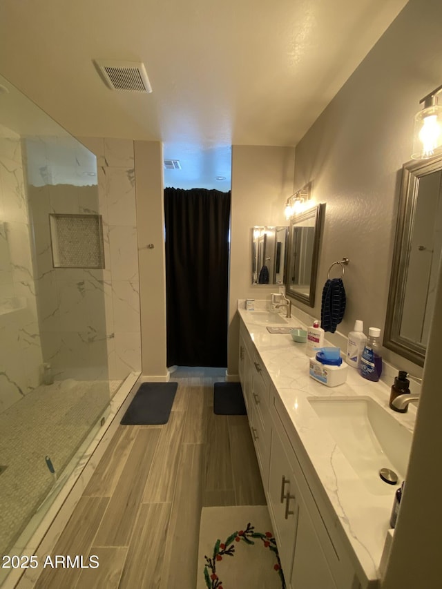 8026 S 6th Dr, Phoenix, AZ 85041 - full bath with visible vents, a sink, wood tiled floor, a marble finish shower, and double vanity
