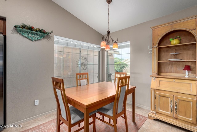 dining space with light tile patterned floors, baseboards, a chandelier, and vaulted ceiling