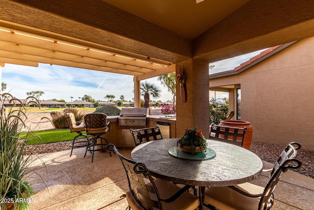 view of patio with exterior kitchen, area for grilling, and outdoor dining space