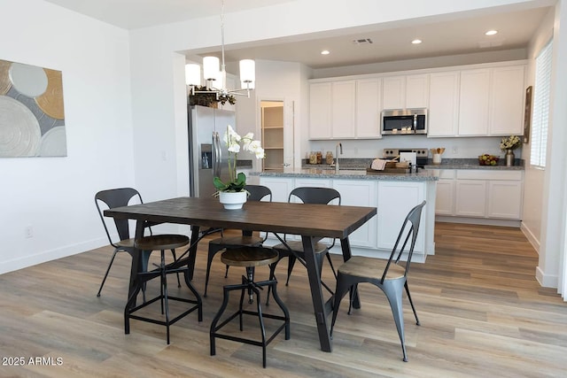 2324 E Marguerite Ave, Phoenix, AZ 85040 - kitchen featuring appliances with stainless steel finishes, a chandelier, light wood-style floors, white cabinets, and recessed lighting