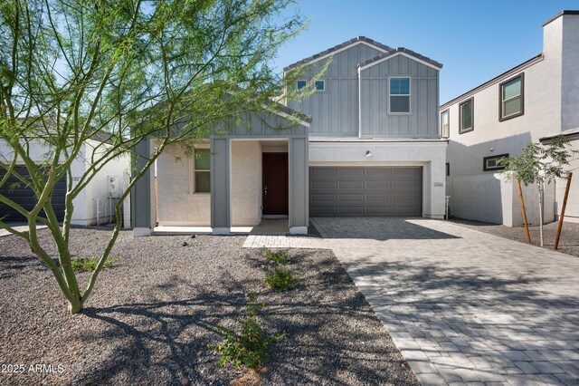 2324 E Marguerite Ave, Phoenix, AZ 85040 - view of front of home featuring board and batten siding, decorative driveway, and a garage