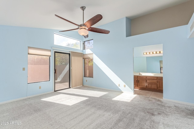 interior space featuring sink, high vaulted ceiling, light colored carpet, and ceiling fan