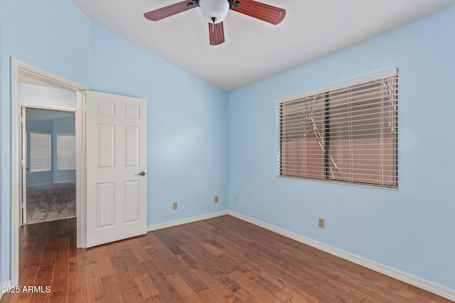 empty room featuring hardwood / wood-style flooring, lofted ceiling, and ceiling fan