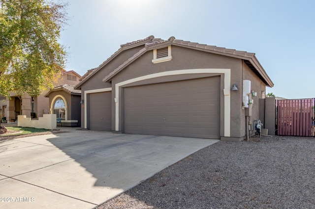 mediterranean / spanish-style house featuring driveway, a tile roof, a garage, and stucco siding