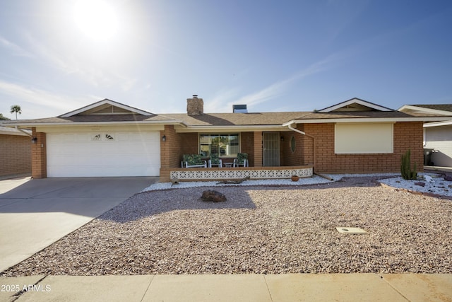 single story home featuring concrete driveway, brick siding, a chimney, and an attached garage