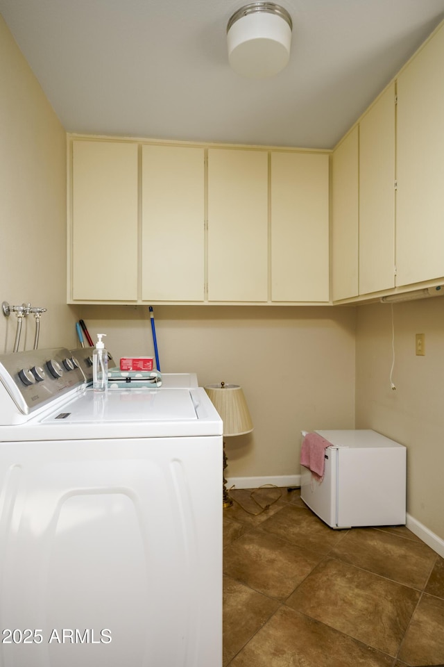 laundry room featuring cabinet space, baseboards, and washing machine and clothes dryer