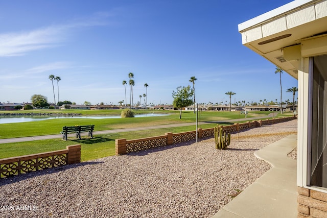 view of home's community with a water view and a yard