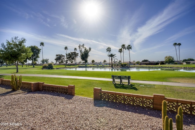 view of home's community with a water view and a yard