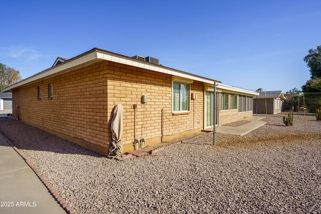 view of side of home with a patio and brick siding