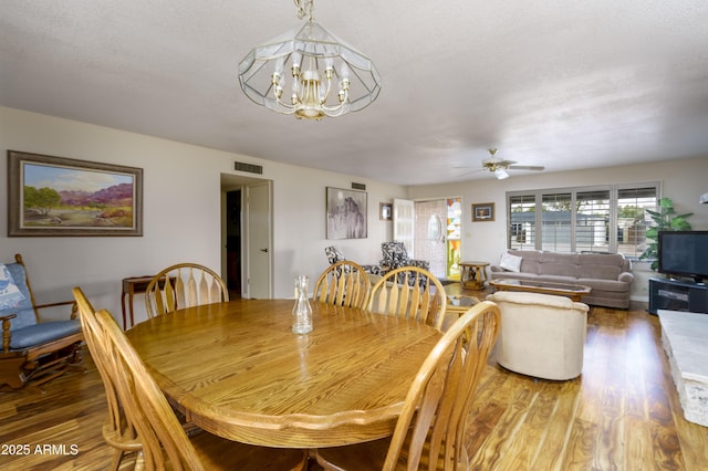 dining area featuring ceiling fan with notable chandelier, light wood-type flooring, and visible vents