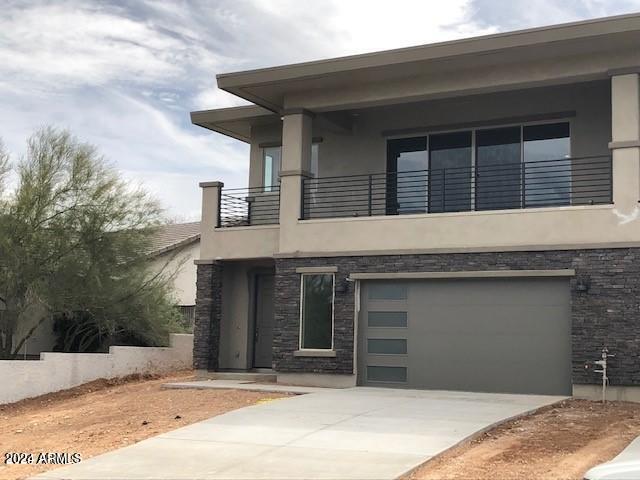 view of front of home with a garage and a balcony