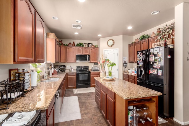 17153 W Gambit Trl, Surprise, AZ 85387 - kitchen featuring black appliances, a center island, light stone counters, recessed lighting, and brown cabinets