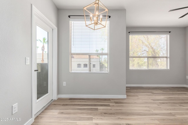 5303 N 7th St Unit 326, Phoenix, AZ 85014 - unfurnished dining area featuring a chandelier, light wood-style flooring, and a ceiling fan