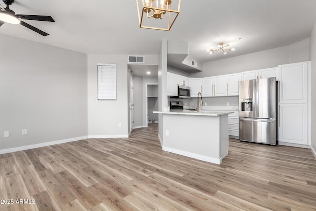 5303 N 7th St Unit 326, Phoenix, AZ 85014 - kitchen with appliances with stainless steel finishes, a chandelier, light countertops, a ceiling fan, and white cabinets