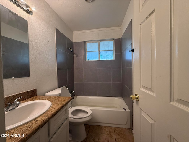 full bathroom featuring tile patterned flooring, vanity, toilet, and tiled shower / bath