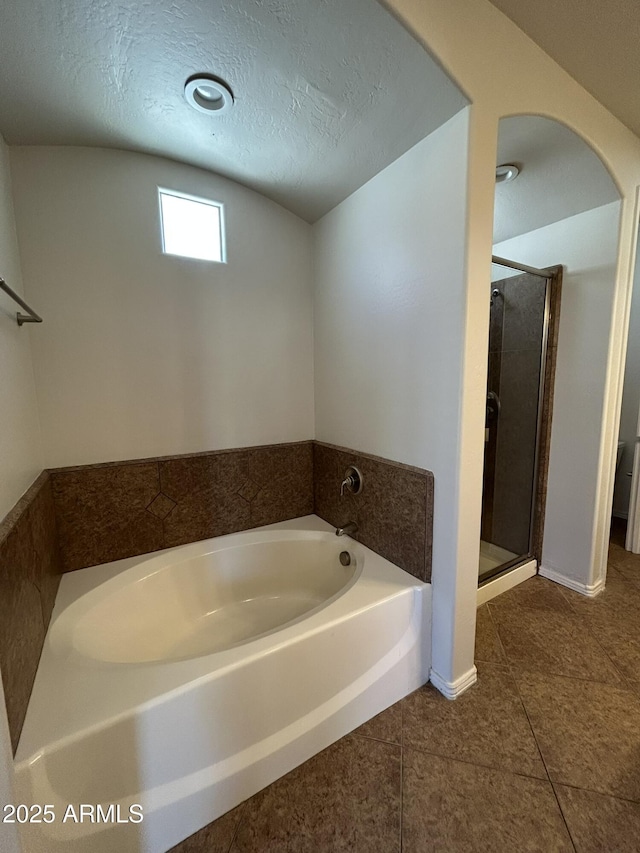 bathroom featuring shower with separate bathtub, tile patterned floors, and a textured ceiling