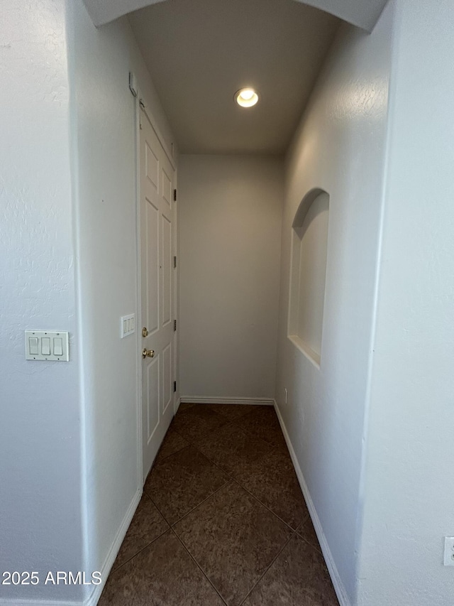 hallway featuring dark tile patterned floors