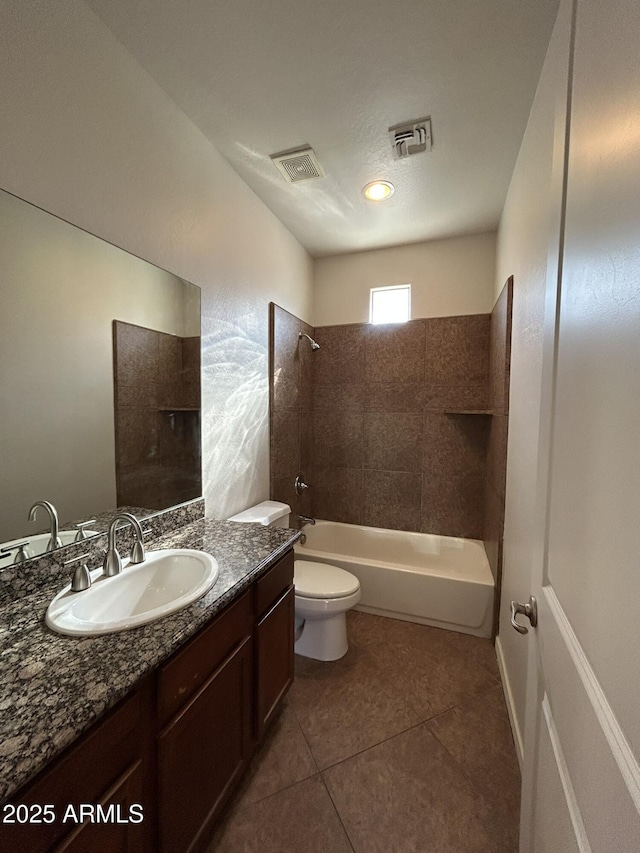 full bathroom featuring tiled shower / bath, vanity, tile patterned floors, and toilet